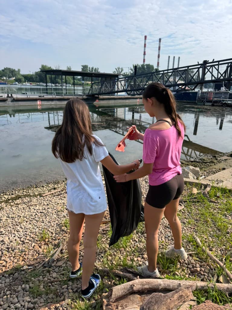 Dve devojke zajedno sakupljaju otpad na obali